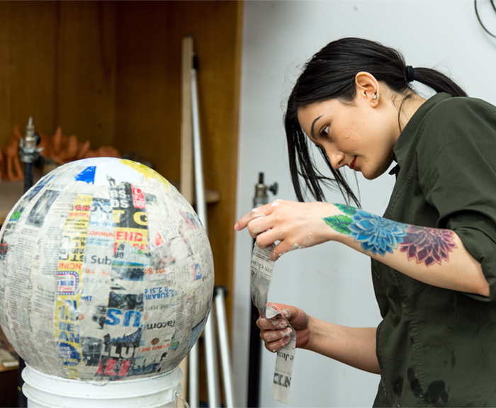 Image of a female art student creating a sculpture