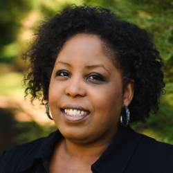 a headshot of an artist with short curly hair