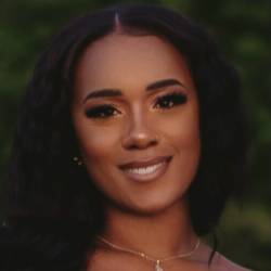 A headshot of an artist with long wavy hair