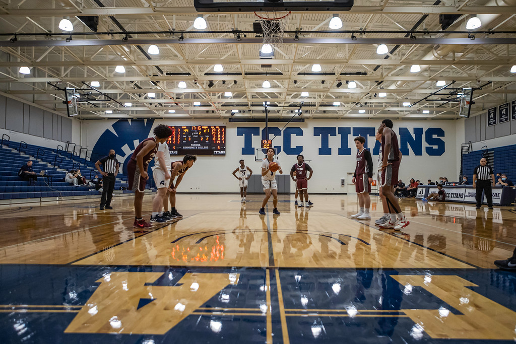 a wide shot of the main athletics gym, picturing students playing basketball