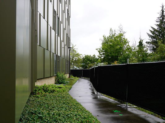 path between Buildings 13 and 10, with the Building 10 side fenced