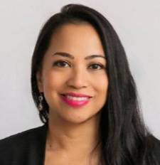 Woman with dark hair and pink lipstick wearing a black blazer