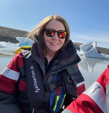 Woman in sunglasses smiles.