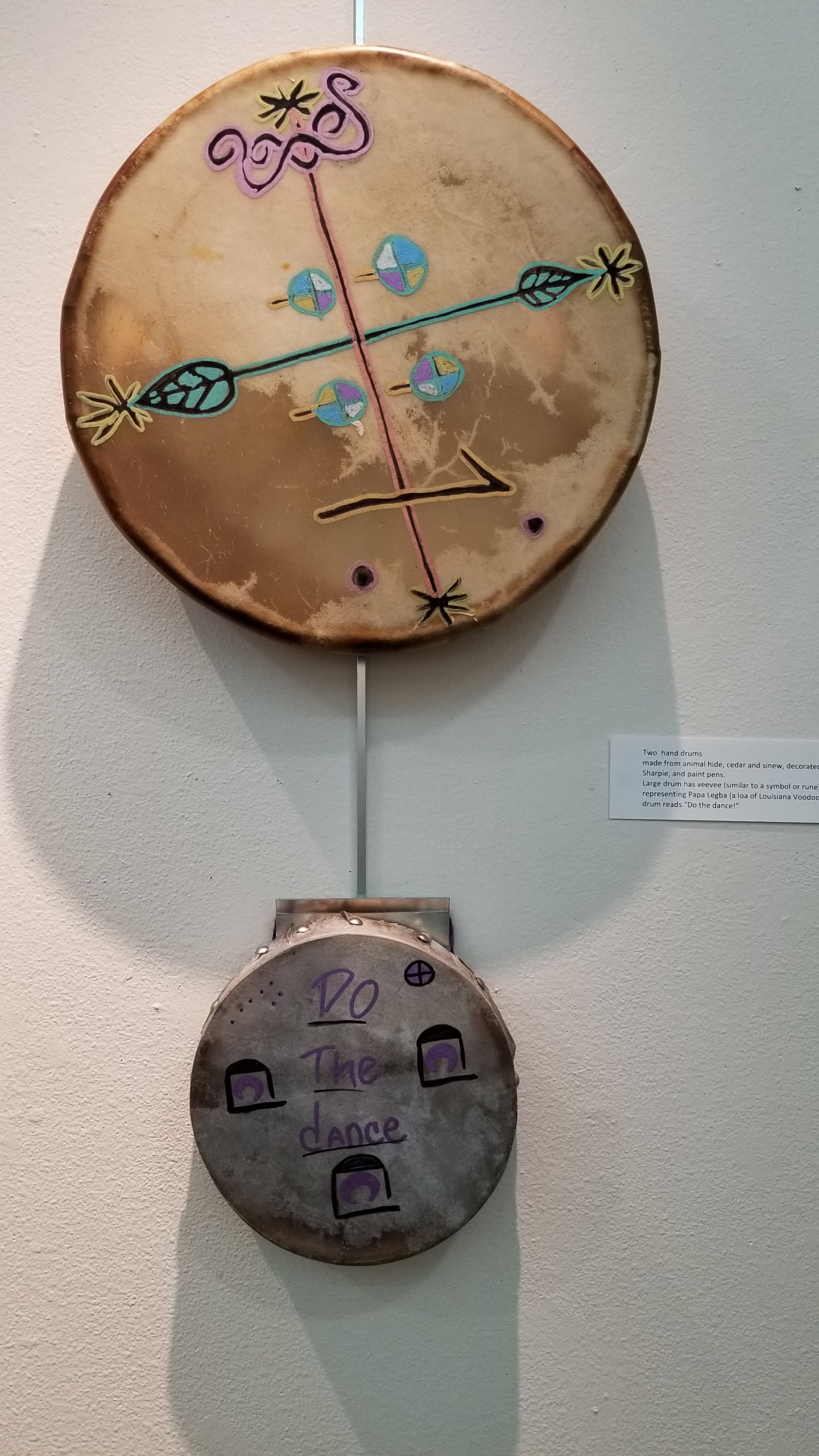 Collaborative Idenity Photo of a sculpture titled "Ceremonial Drums" on a wall
