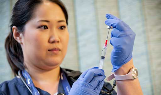 A nursing student fills a needle