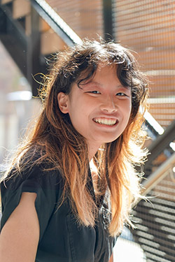 Picture of a woman with long brown hair in a black shirt smiling.