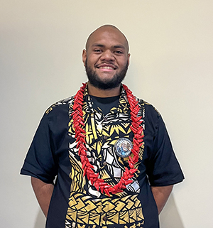 A man with a lei smiling. 